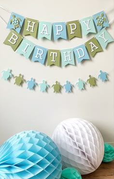 a turtle themed birthday party with paper decorations and tissue pom poms on the table