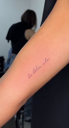 a woman with a tattoo on her arm that says, i am believe star in cursive writing