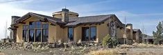 a large house sitting on top of a dry grass field