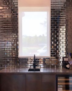 a kitchen with stainless steel tiles on the backsplash and counter tops, along with a wine rack