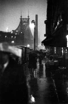 black and white photograph of people walking in the rain