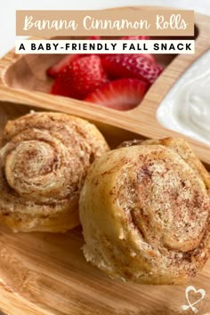 cinnamon rolls on a wooden plate with strawberries and yogurt in the background