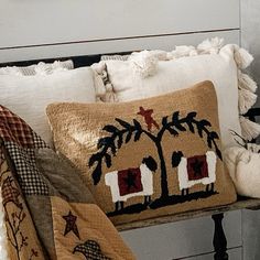 pillows and blankets are on a bench in front of a wall with an image of a palm tree