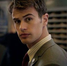 a young man in a suit and tie looking at the camera with an intense look on his face