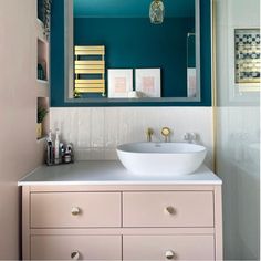 a white sink sitting on top of a bathroom counter next to a blue and yellow wall