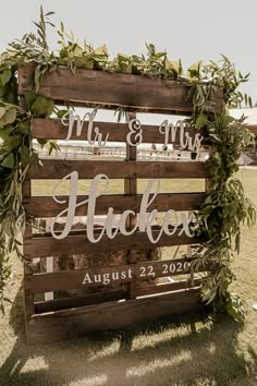 a wooden sign with greenery on it