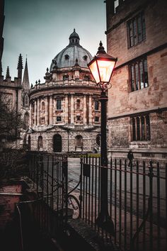 a street light in front of an old building with a dome on it's roof