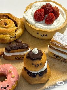 there are many different pastries on the wooden tray with strawberries and creams