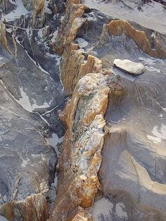 an aerial view of some rocks in the desert with snow on them and one rock sticking out of the ground