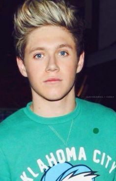 a young man with blonde hair wearing a green shirt