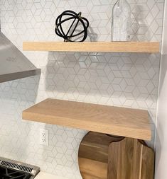 a stove top oven sitting inside of a kitchen next to a wooden shelf above it