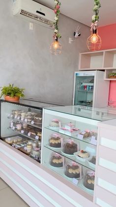 a bakery filled with lots of cakes and cupcakes next to a wall mounted air conditioner