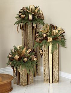 two decorative boxes with bows on them sitting next to each other in front of a wall