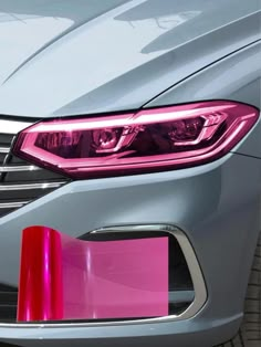 the front end of a silver car with pink trim