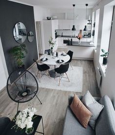 a living room filled with furniture next to a kitchen and dining room table on top of a hard wood floor