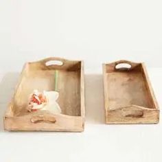 two wooden trays with handles on each side, one holding a flower and the other holding a toothbrush