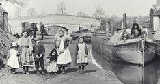 an old black and white photo of people standing next to a boat