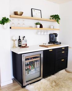 an instagramted photo of a kitchen with black cabinets and white countertops, including a refrigerator