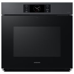 a black oven with the door open and clock on it's side, in front of a white background