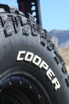 closeup of the tire on a jeep with mountains in the background