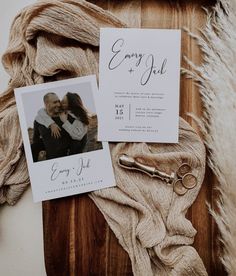 an image of wedding stationery on top of a wooden table with two photos and a pair of scissors