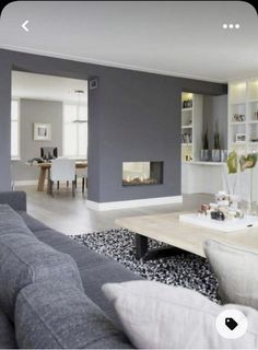 a living room filled with furniture and a fire place in the middle of it's wall