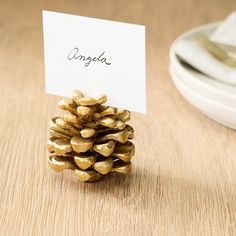 a place card holder made out of gold hearts on a wooden table next to silverware