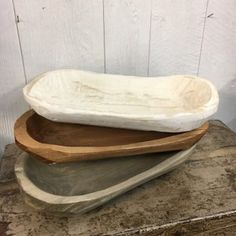 two wooden bowls sitting on top of each other