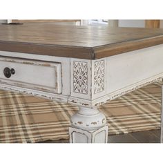 an antique white coffee table with drawers