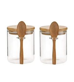 two glass jars with wooden spoons on the top one is empty and the other has a lid