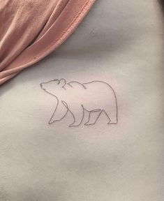 a woman's stomach with a small bear tattoo on the left side of her stomach