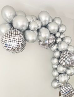 a bunch of silver balloons hanging from the ceiling