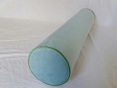 a blue and green cone shaped object sitting on top of a white sheeted bed