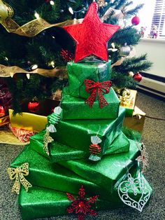 a christmas tree made out of green wrapping paper with red and gold stars on top