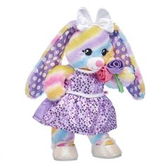 a stuffed animal that is wearing a dress and holding a flower in it's hand