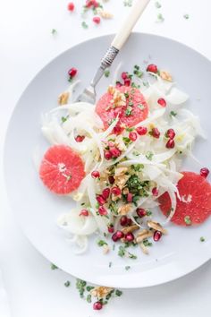 a white plate topped with sliced up grapefruit and shaved fennel slaw