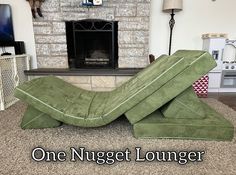 a green couch sitting in front of a fire place with the words, one nugett lounger