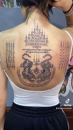 the back of a woman's shoulder with tattoos on it