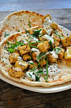 there is a tortilla with tofu and sauce on it sitting on a plate