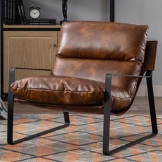 a brown leather chair sitting on top of a rug