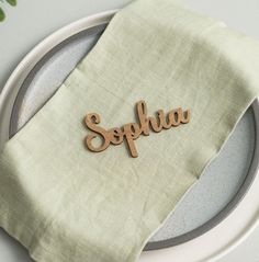 a plate with a napkin on it that has the word sophia spelled in wooden letters