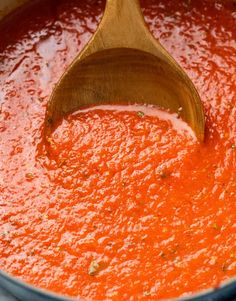 a wooden spoon is in a red sauce