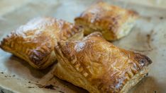 three pastries sitting on top of a piece of wax paper