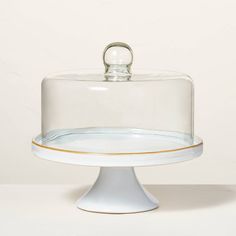 a glass cake plate with a clear cover on top