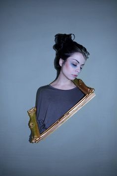 a woman with her eyes closed is holding a gold frame