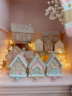 three gingerbread houses are sitting on a shelf