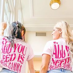 two women wearing pink shirts that say, do you feed us some cama?