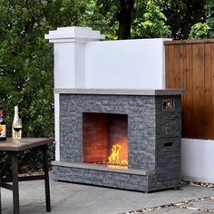 an outdoor fireplace is shown with wine bottles on the table