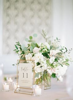 there is a vase with flowers and candles on the table in front of an orange frame