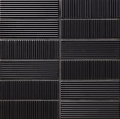 a black and white tile wall with vertical lines